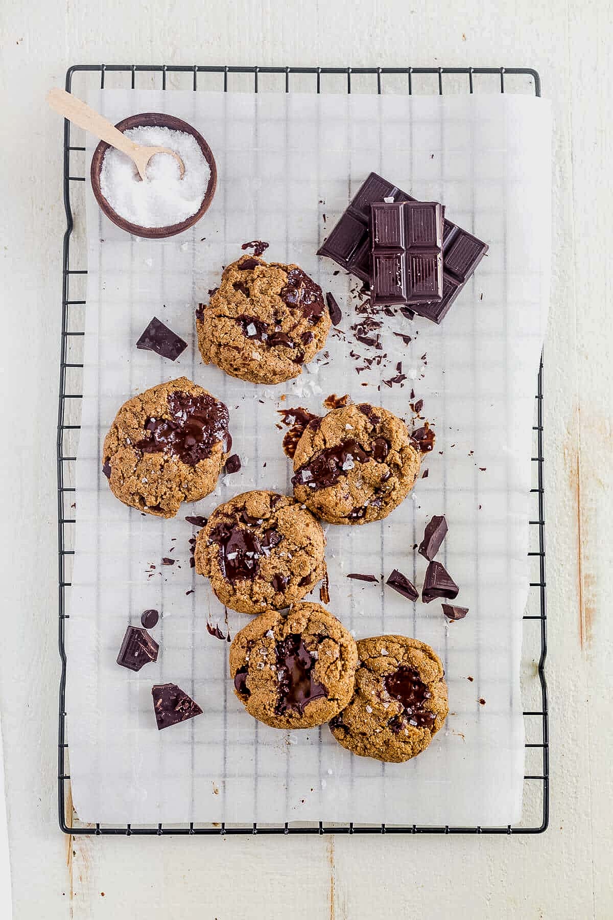 a batch of coconut flour chocolate chip cookies cooling on parchment paper