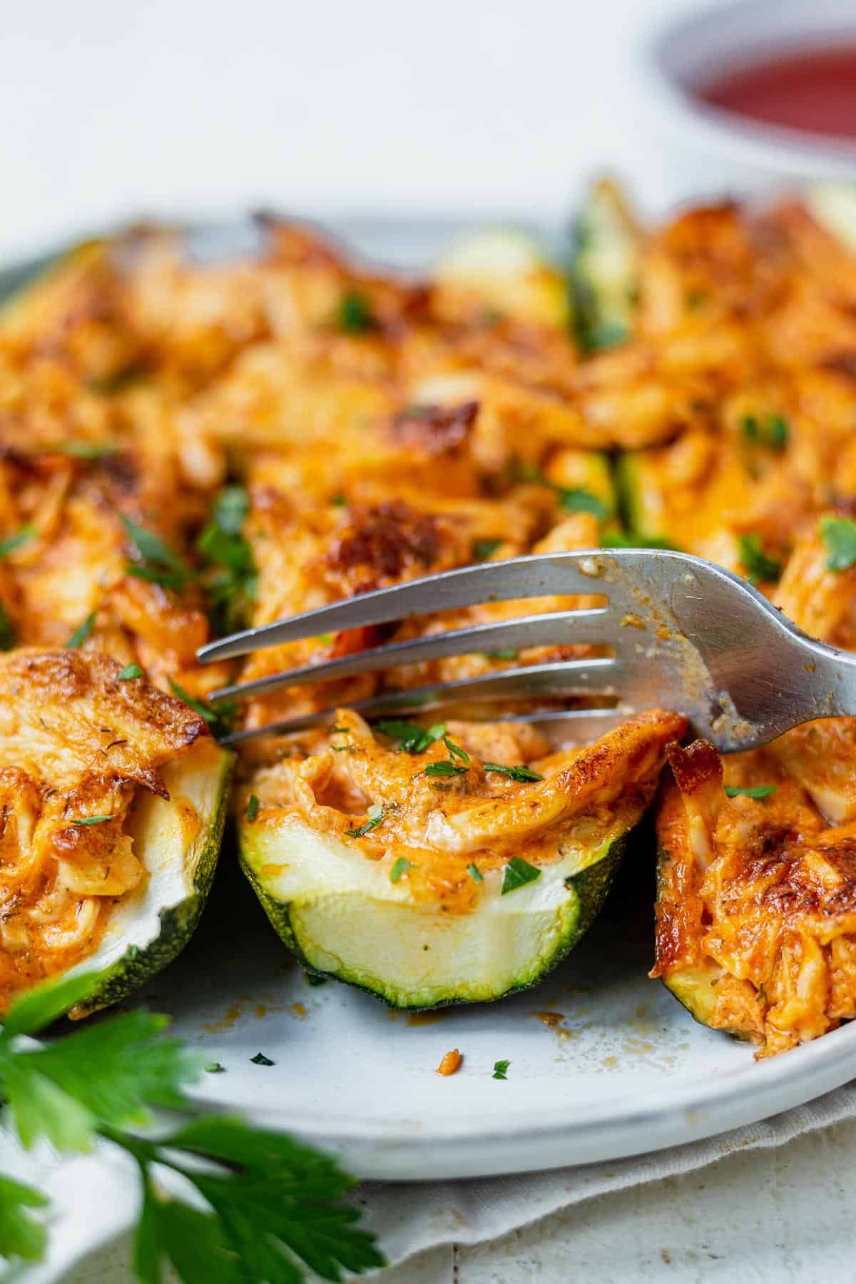cutting into a zucchini boat filled with buffalo chicken