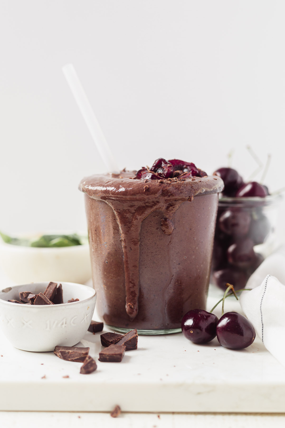 chocolate cherry smoothie in a glass jar with fresh cherries on top