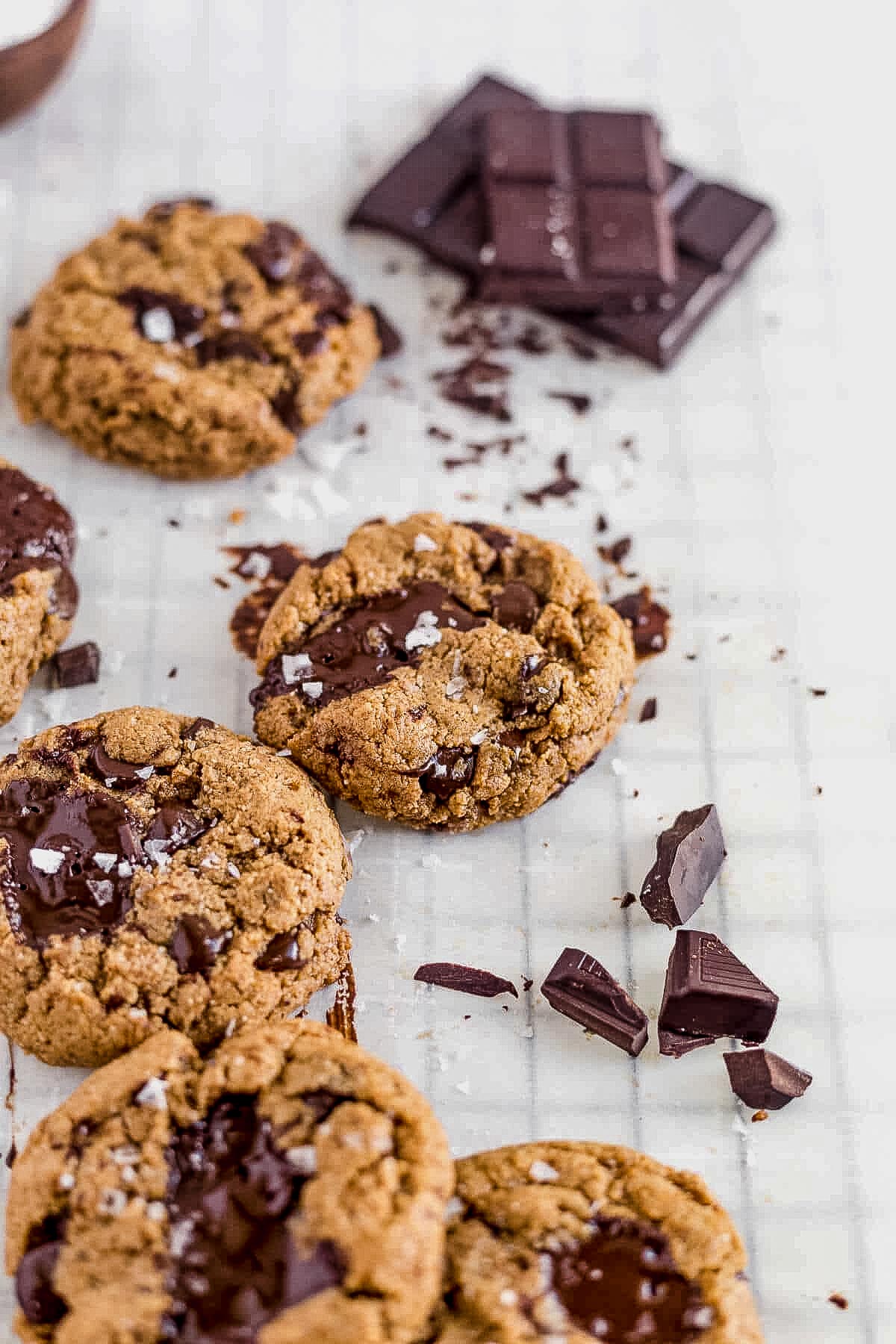 keto coconut flour chocolate chip cookies cooling next to a bar of dark chocolate