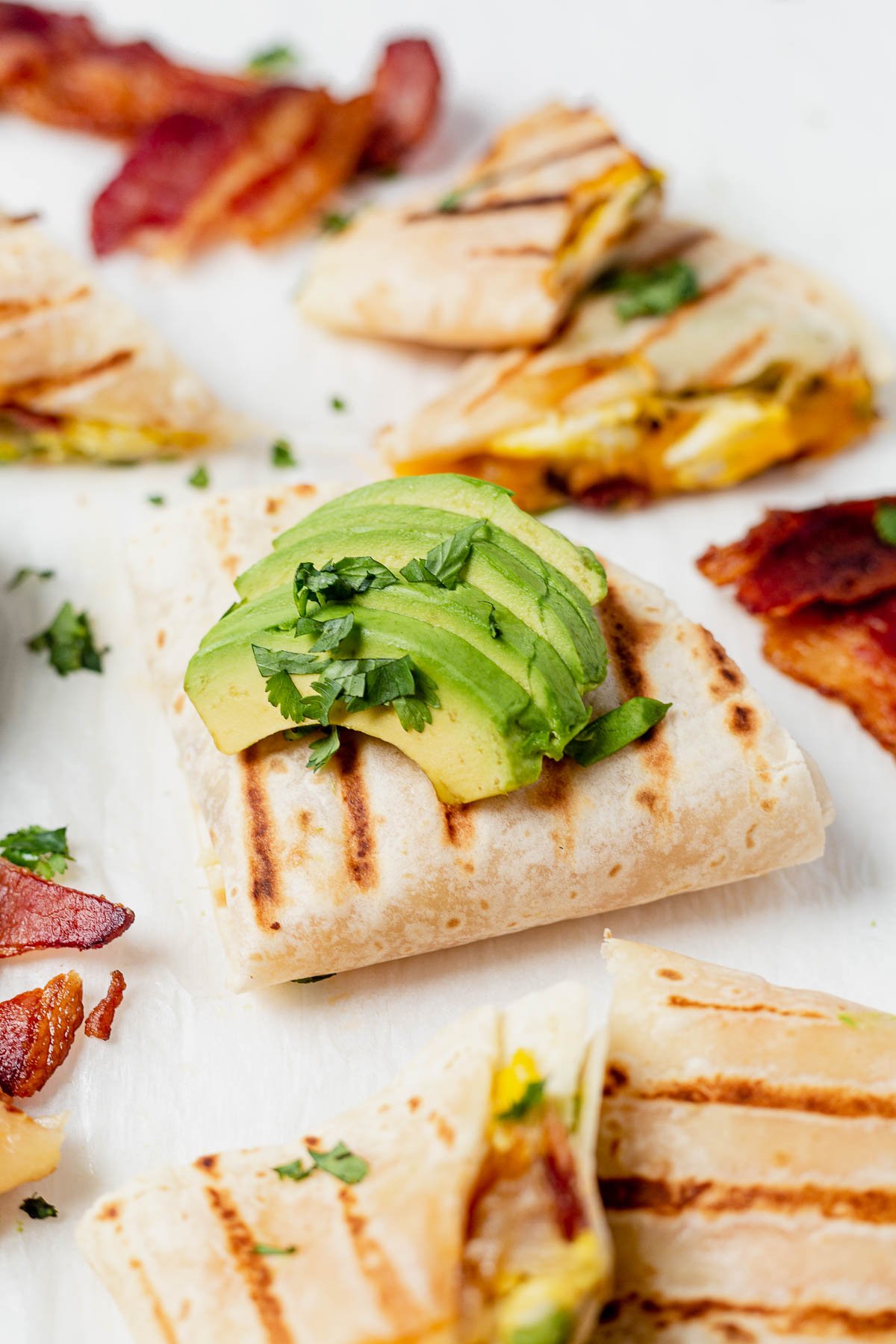 healthy breakfast quesadilla topped with avocado and cilantro