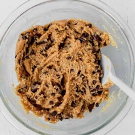 healthy cookie dough in a glass bowl with a spatula