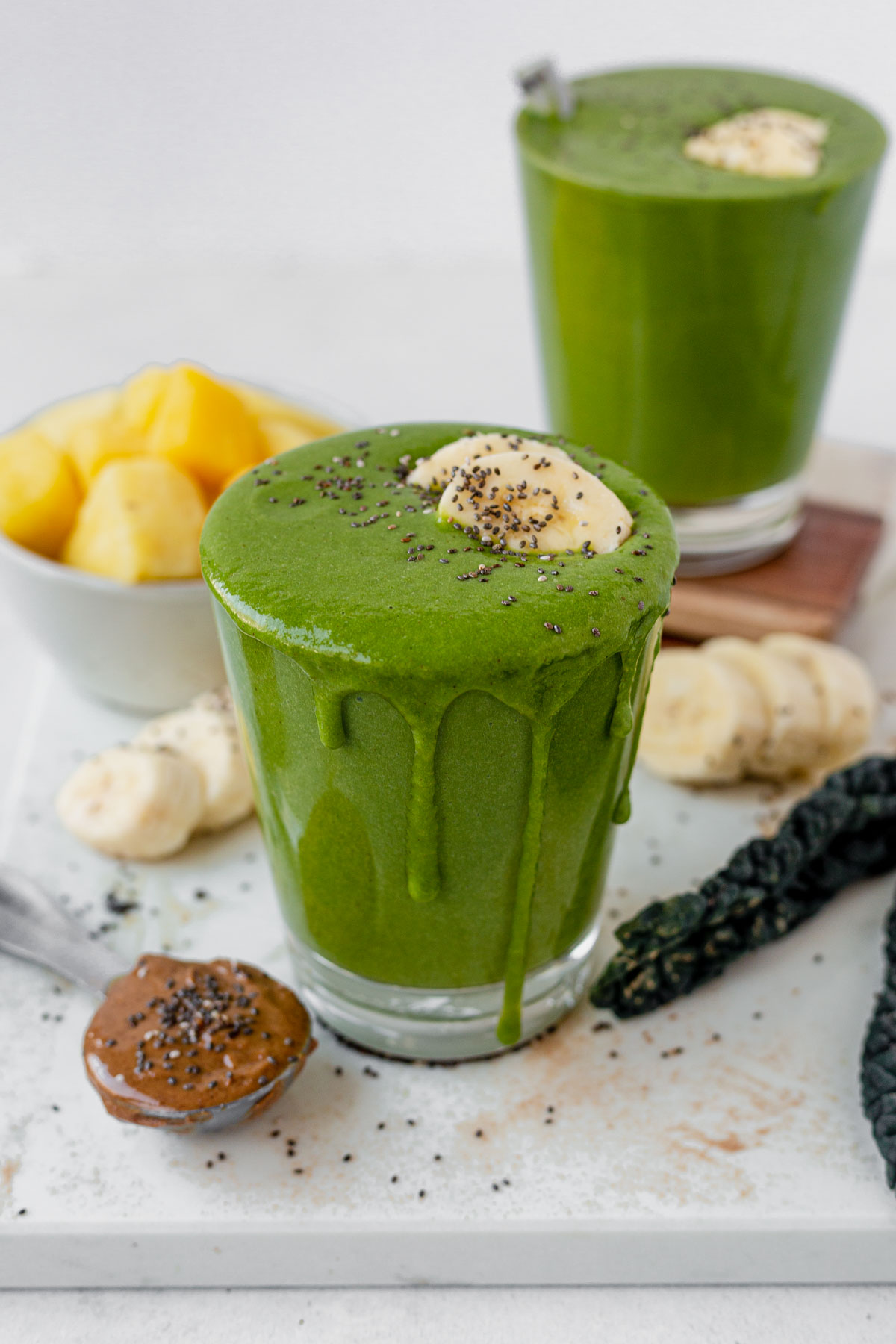 a kale smoothie in a glass topped with chia seeds and banana