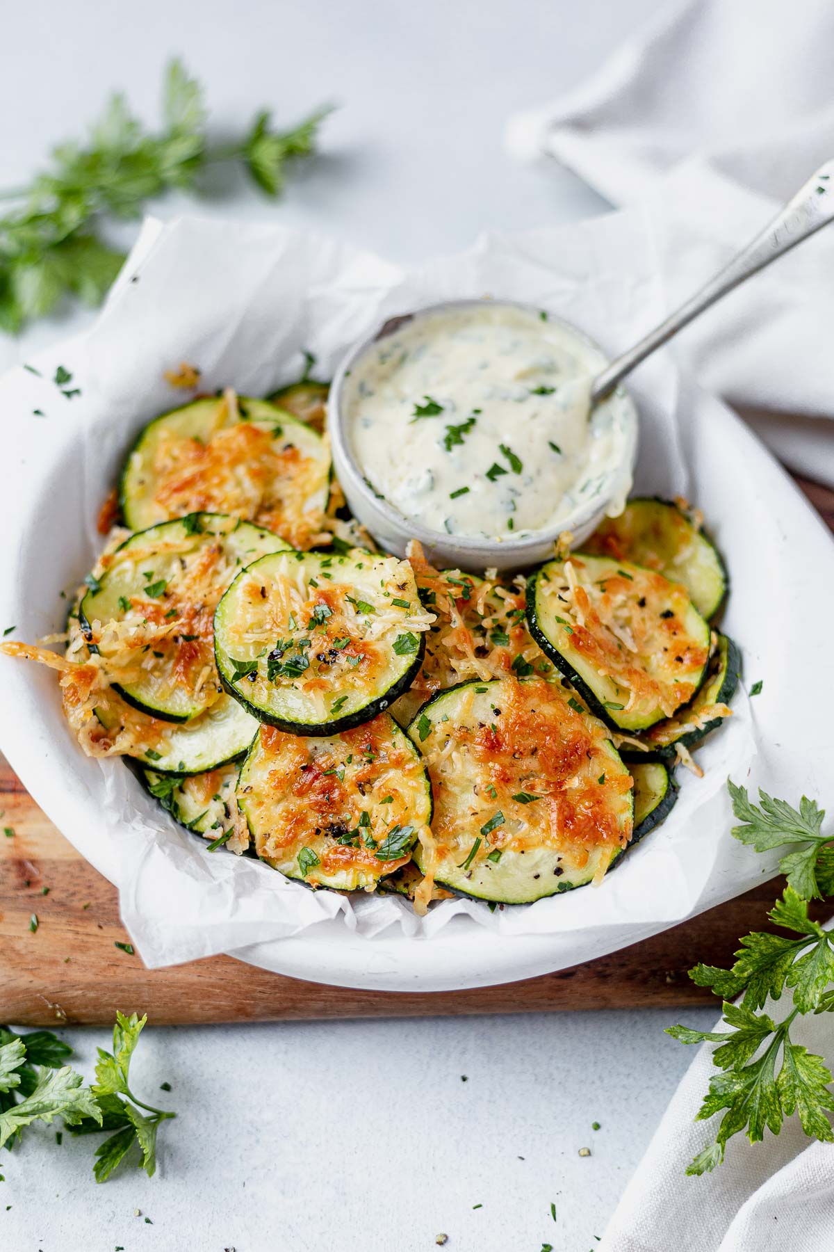 zucchini chips in a white dish topped with parsley and served with rnch