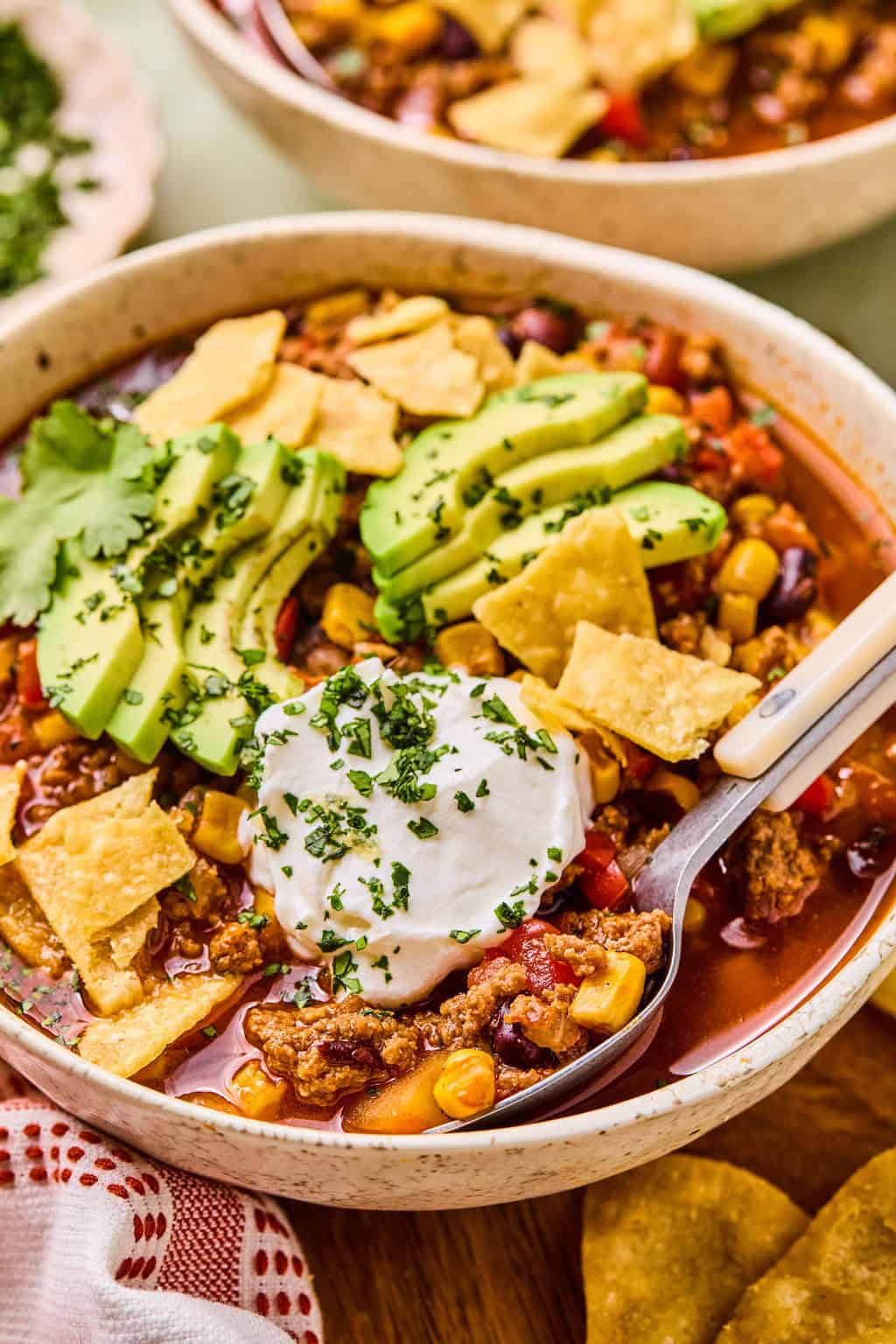 scooping taco soup out of a bowl.