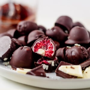 a plate of chocolate covered raspberries