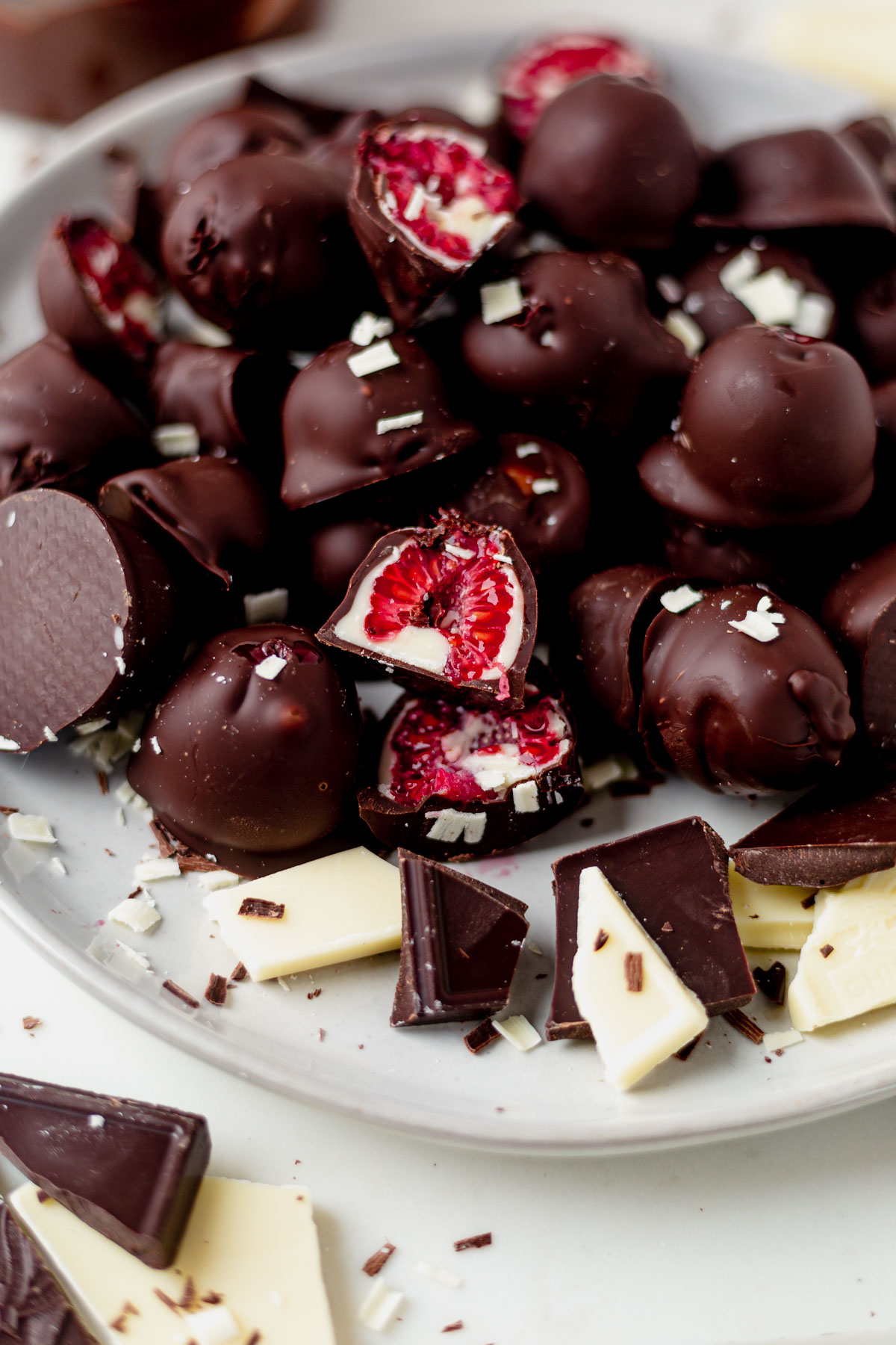 white and dark chocolate covered raspberries on a serving platter