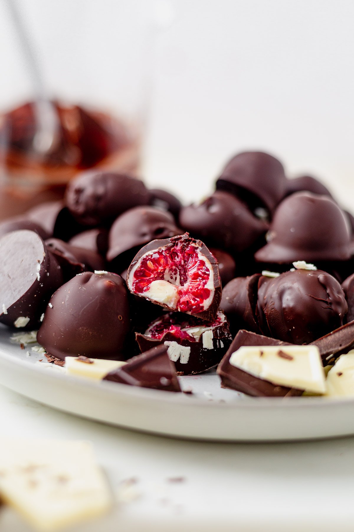 a plate of chocolate covered raspberries