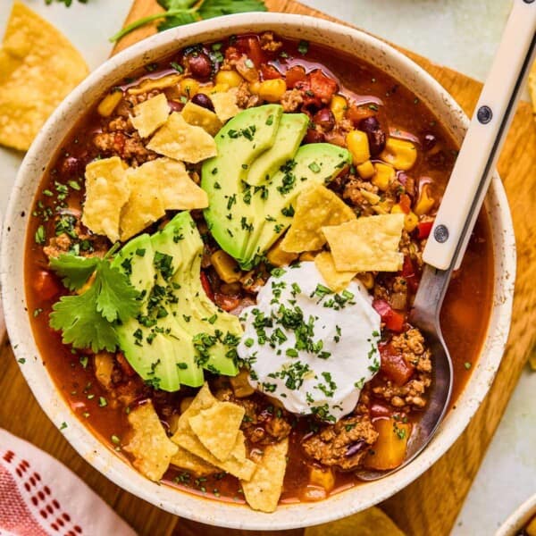 a bow of instant pot taco soup with sour cream and avocados on top.