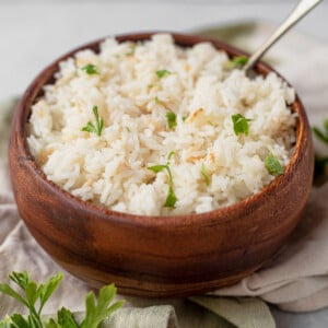 fluffy coconut rice in a wood bowl with a spoon
