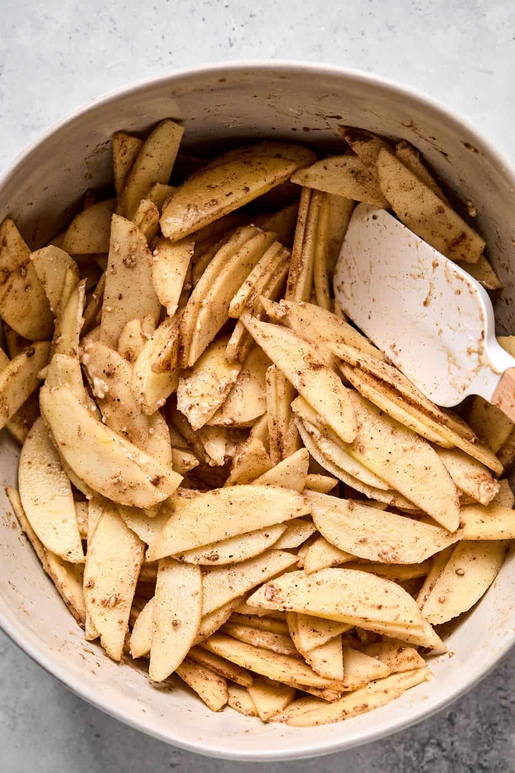 sliced apple crisp filling in a mixing bowl.