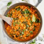 sweet potato curry in a serving dish with fresh cilantro and lime