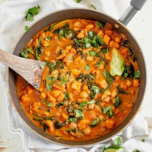 sweet potato curry in a serving dish with fresh cilantro and lime