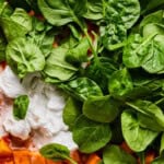 stirring coconut milk and spinach into sweet potato curry.