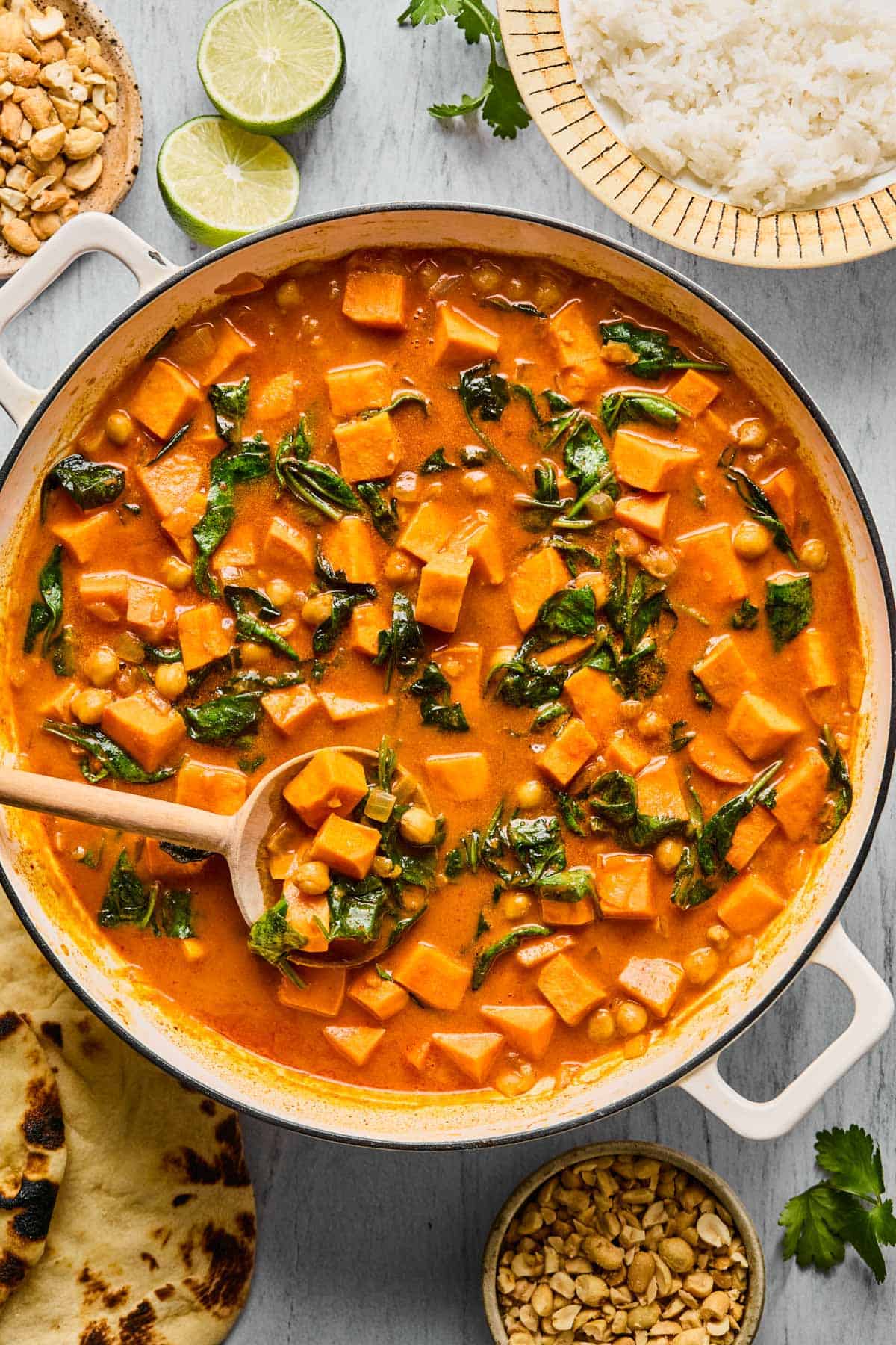a big pot of sweet potato coconut curry with a ladle.
