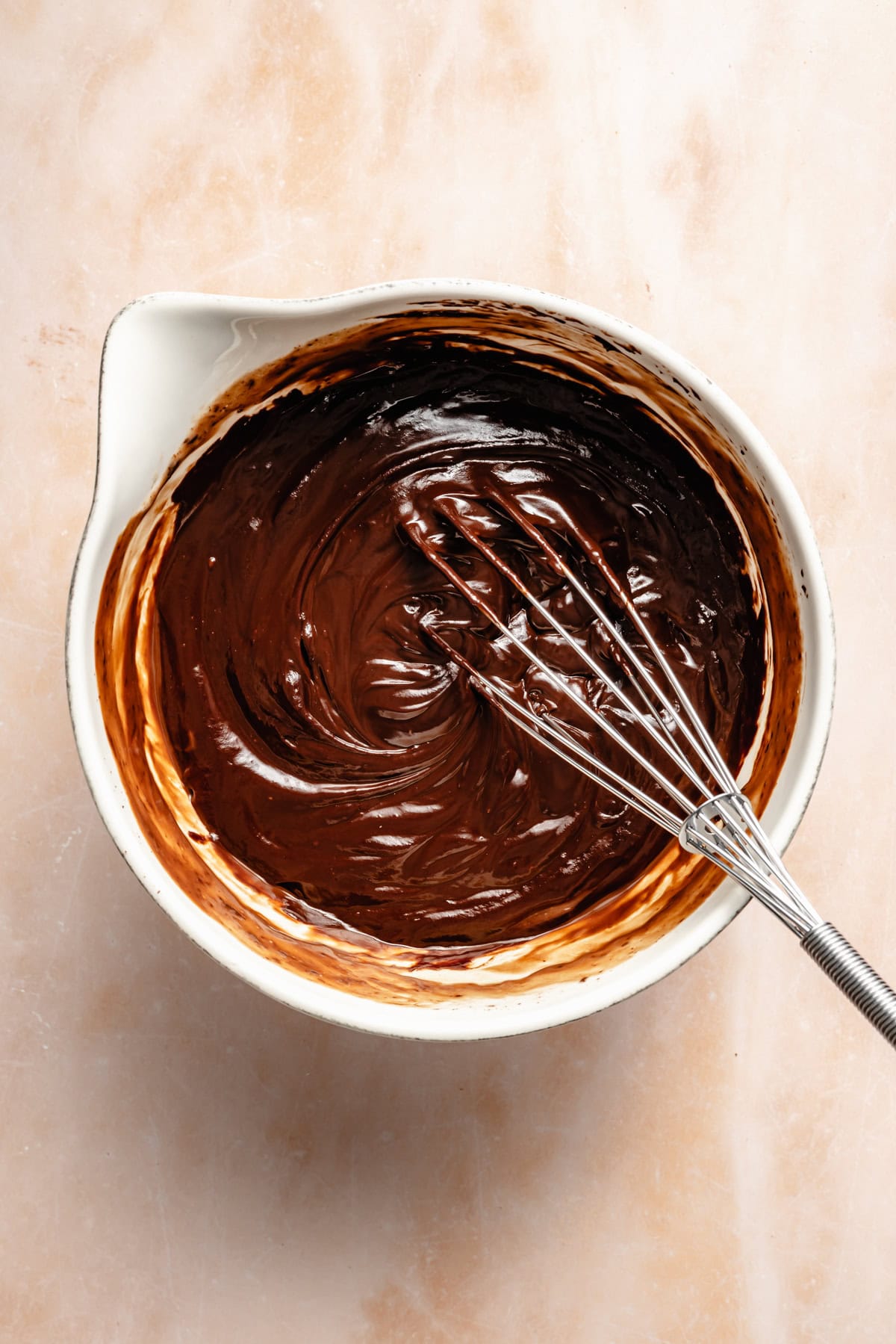 stirring chocolate ganache in a mixing bowl.