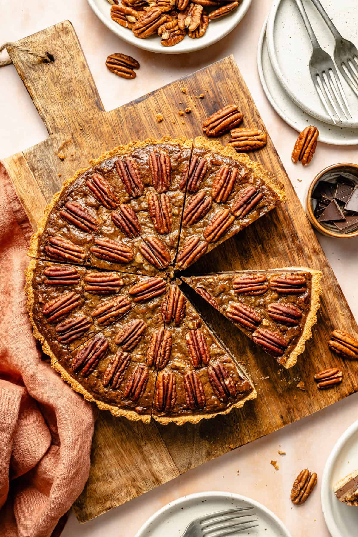 chocolate paleo pecan pie in a pie dish with a piece missing.