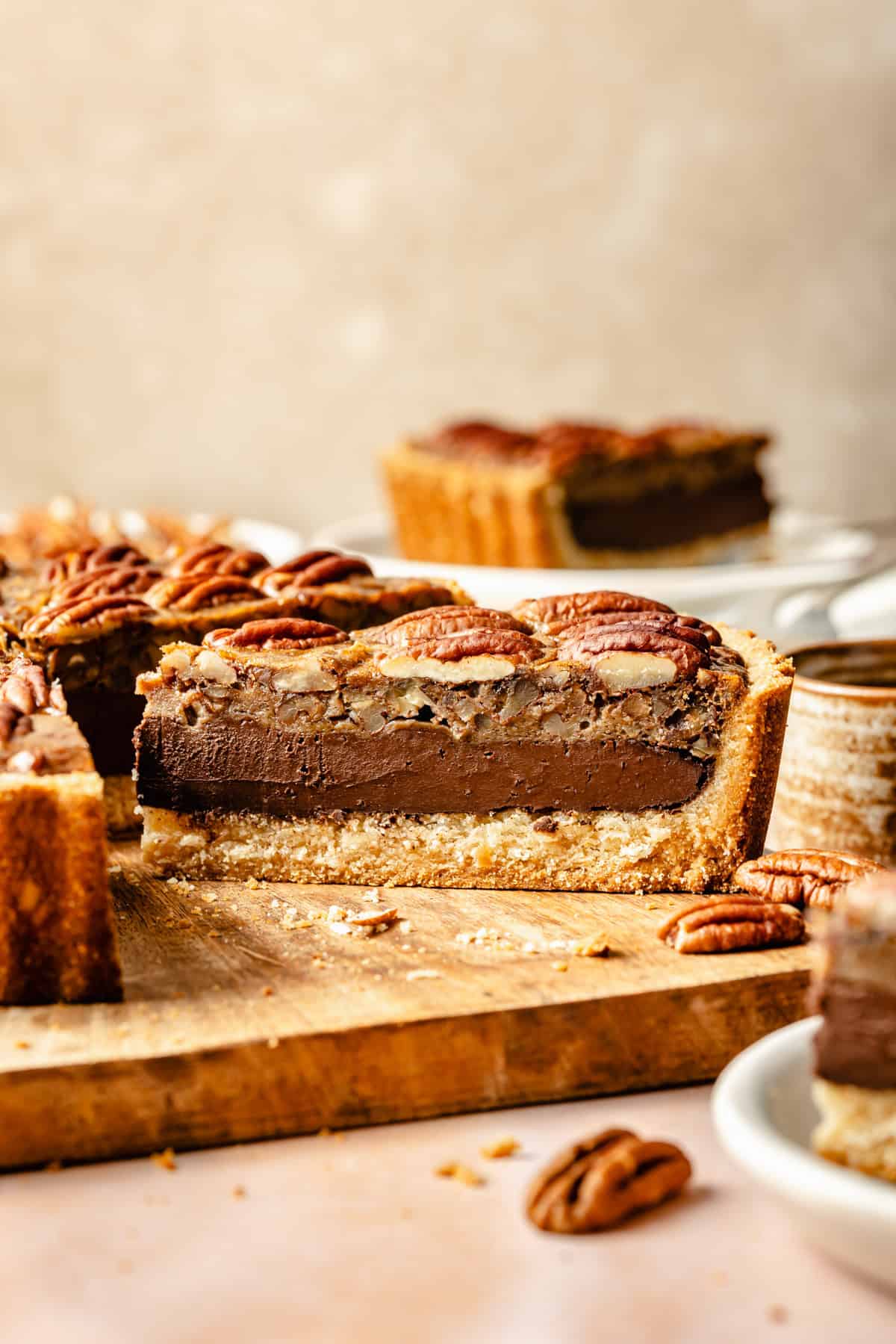 a slice of chocolate paleo pecan pie on a serving board.