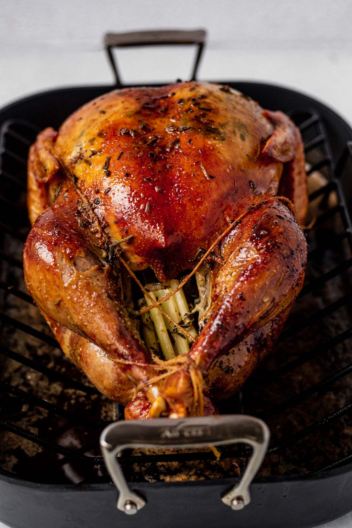 cheesecloth turkey in a black roasting pan with brown crispy skin