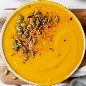 creamy panera autumn squash soup recipe swirled in a bowl and topped with pumpkin seeds