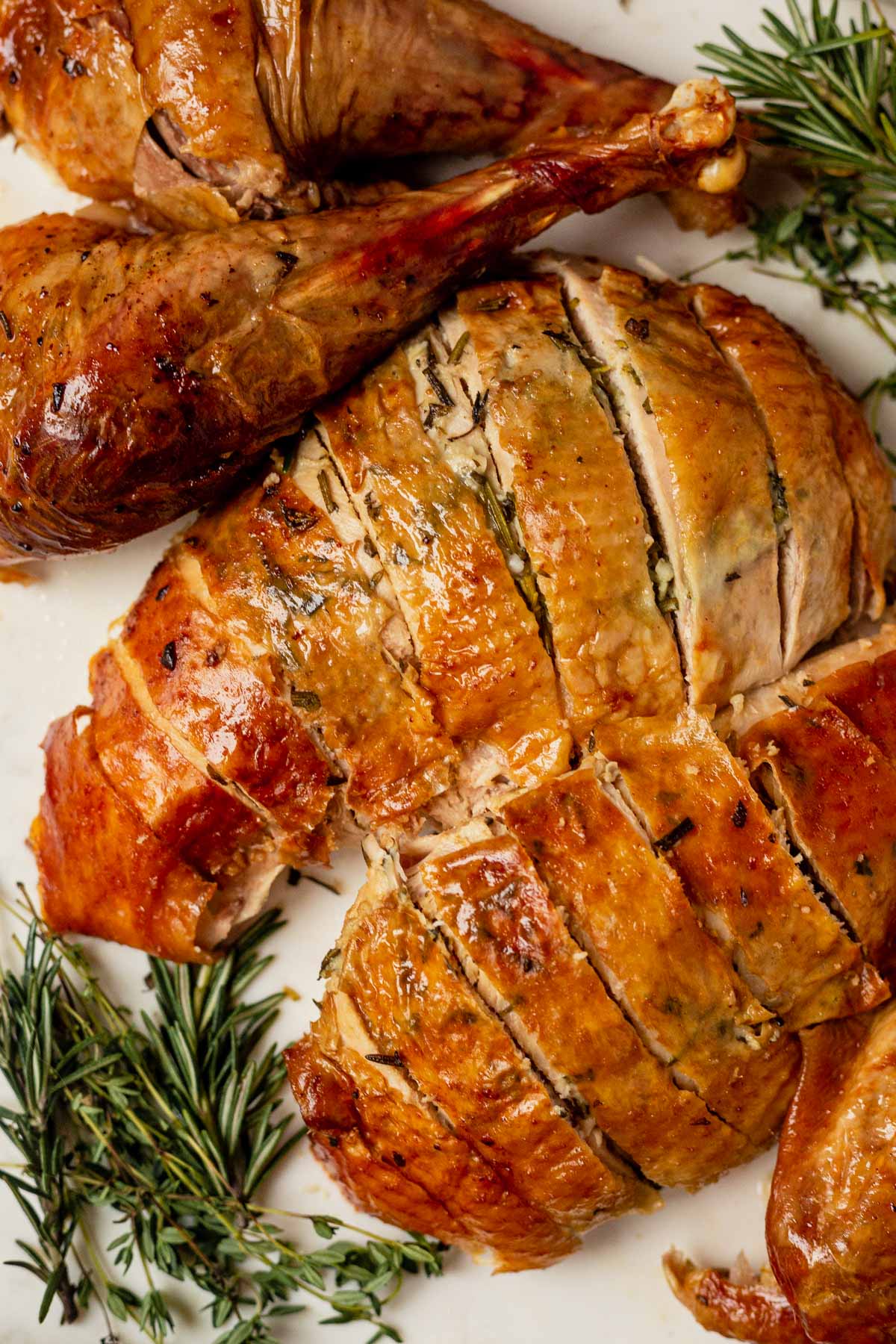 roasted turkey breasts with crispy golden skin carved and served on a white platter