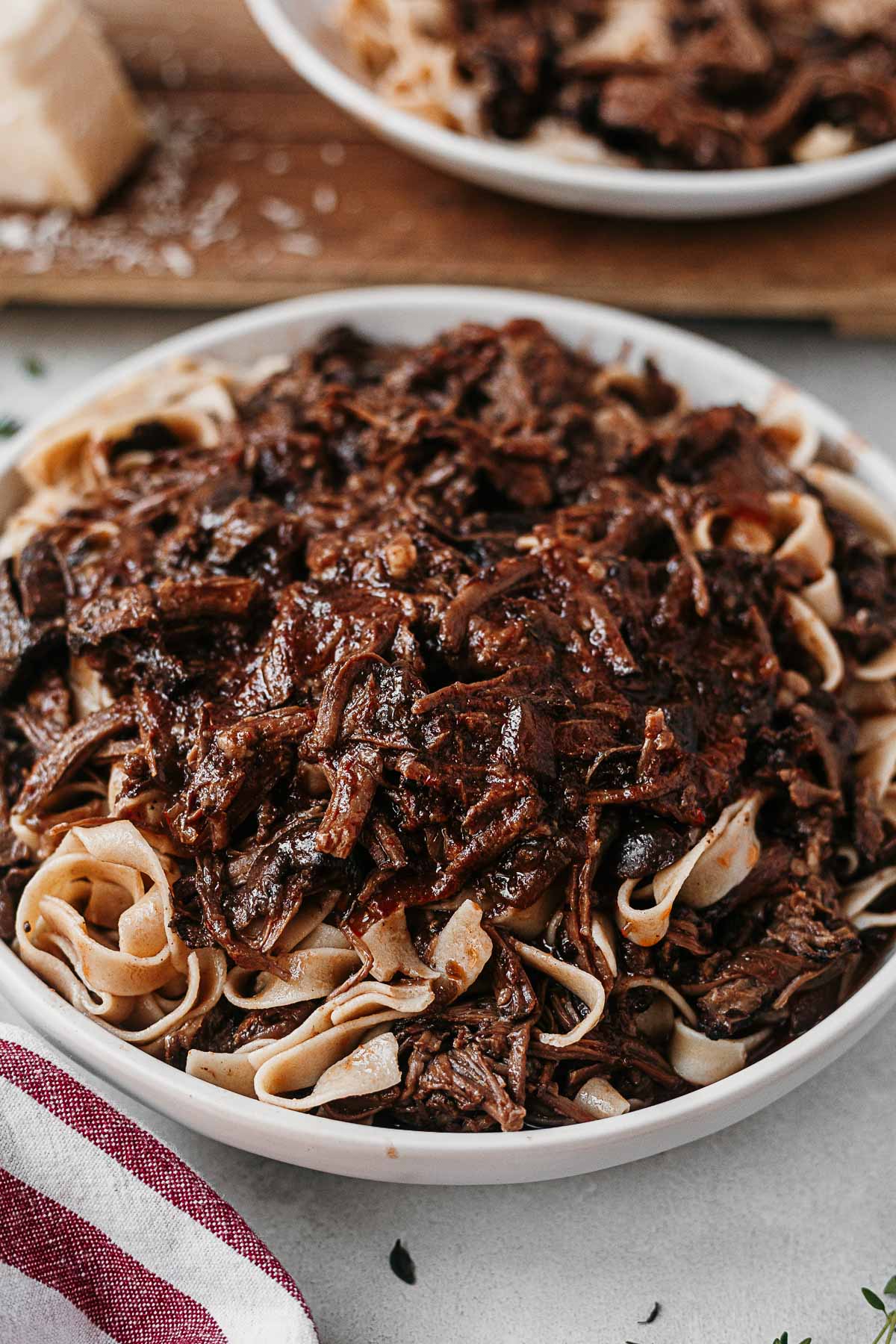 short rib pasta sauce served over noodles in a white bowl