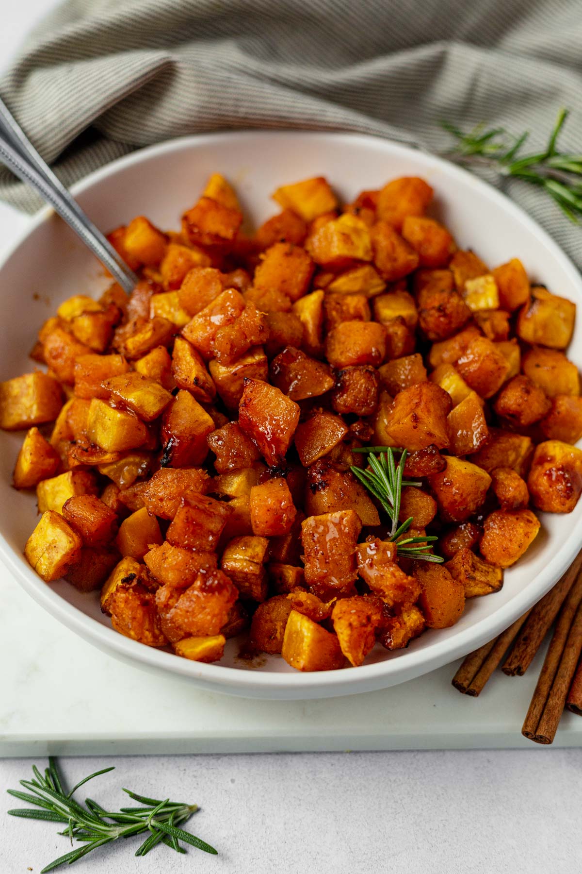 air fryer butternut squash in a white serving bowl with a spoon