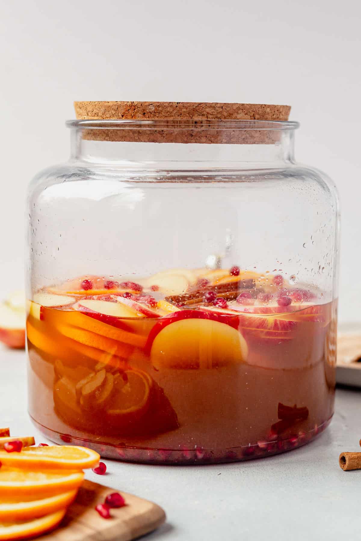 apple cider sangria with fresh fruit in a large pitcher on the counter.