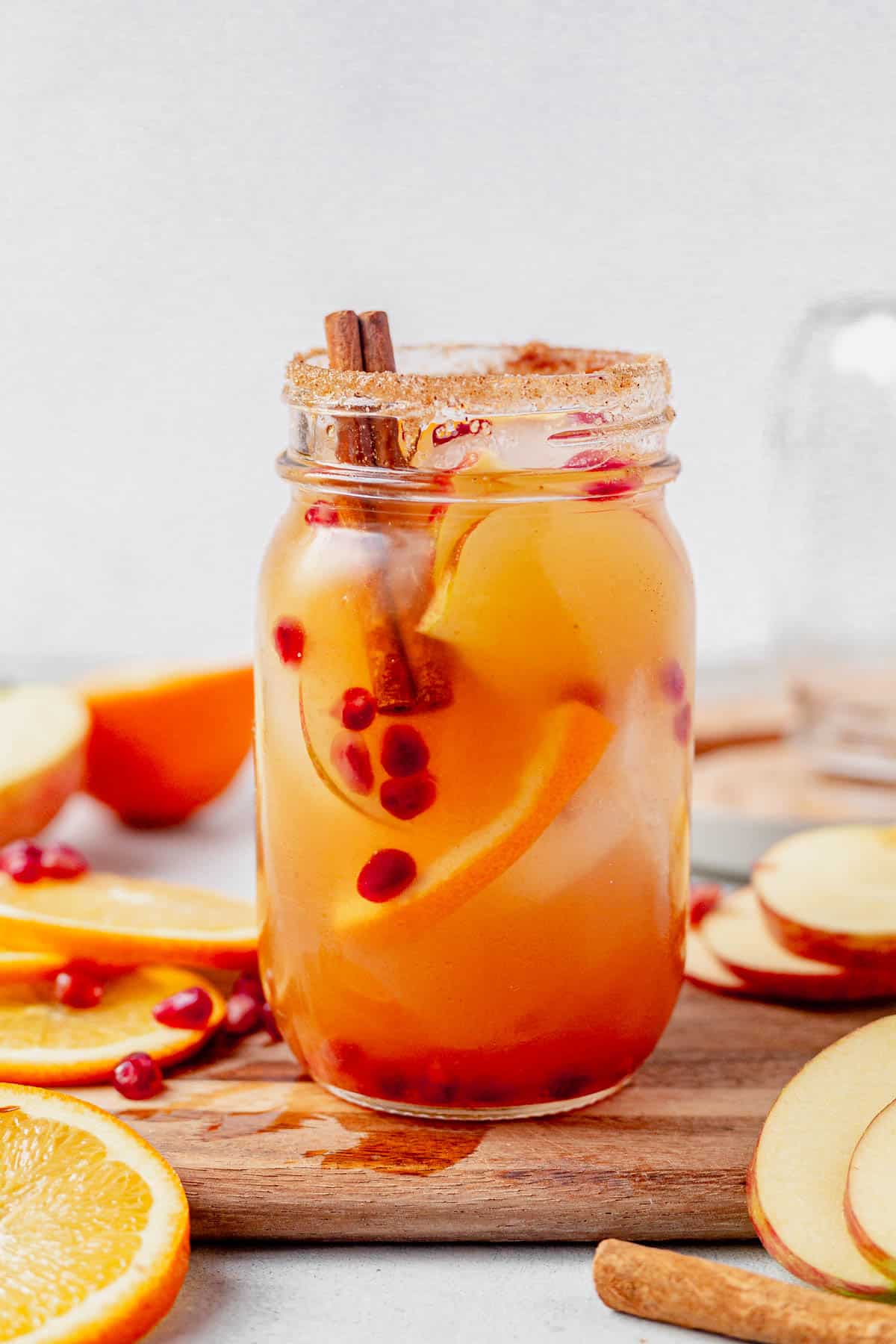 apple cider sangria in a mason jar with a cinnamon sugar rim.