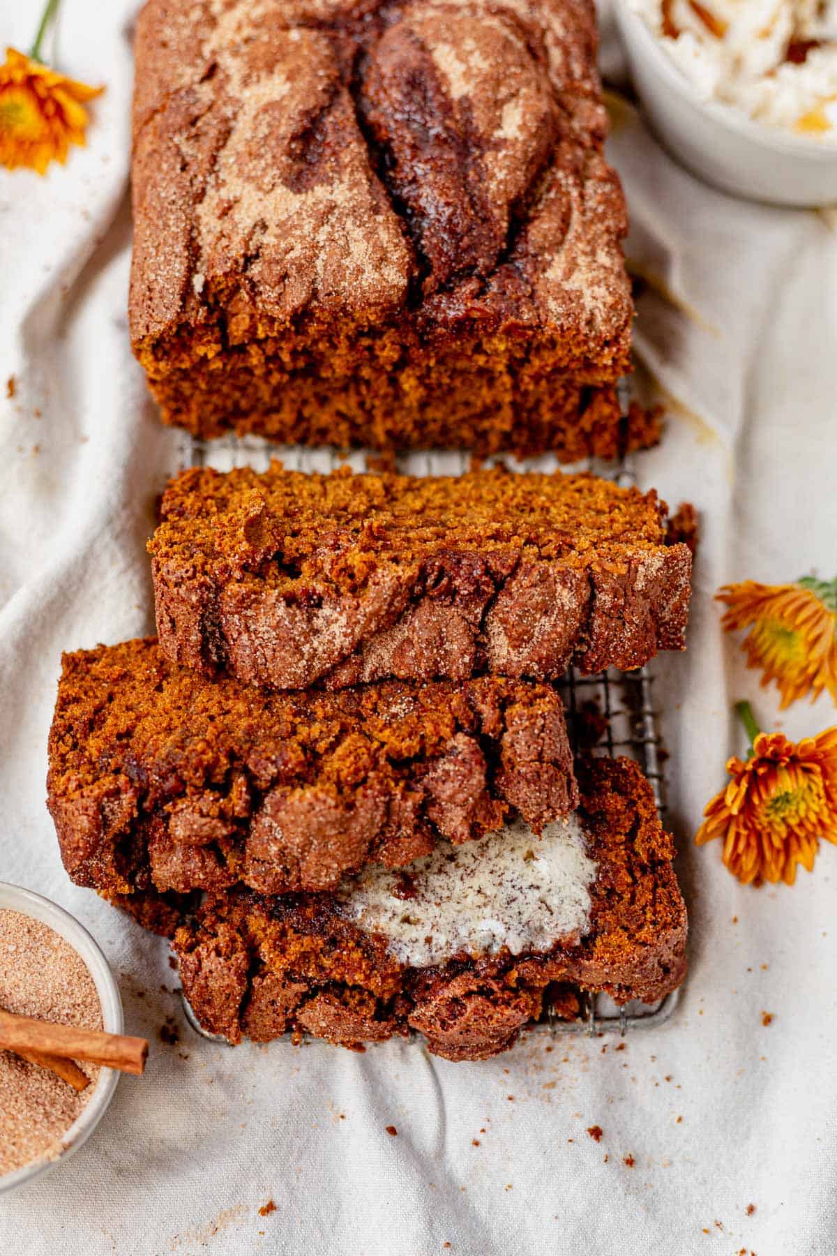 a sliced loaf of cinnamon swirl pumpkin bread on a cooling rack.