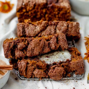 three slices of gluten free pumpkin bread stacked with melted butter