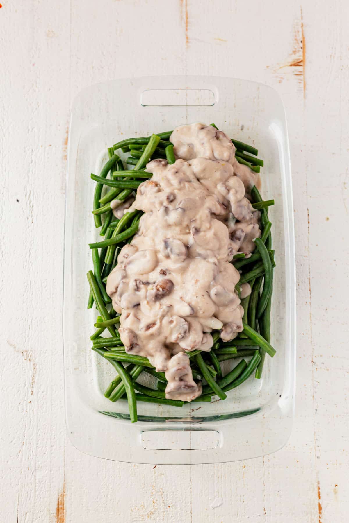 green beans and gluten free dairy free mushroom sauce in a casserole dish.