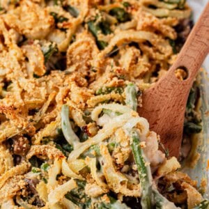 scooping a serving of gluten and dairy free green bean casserole from a serving dish.