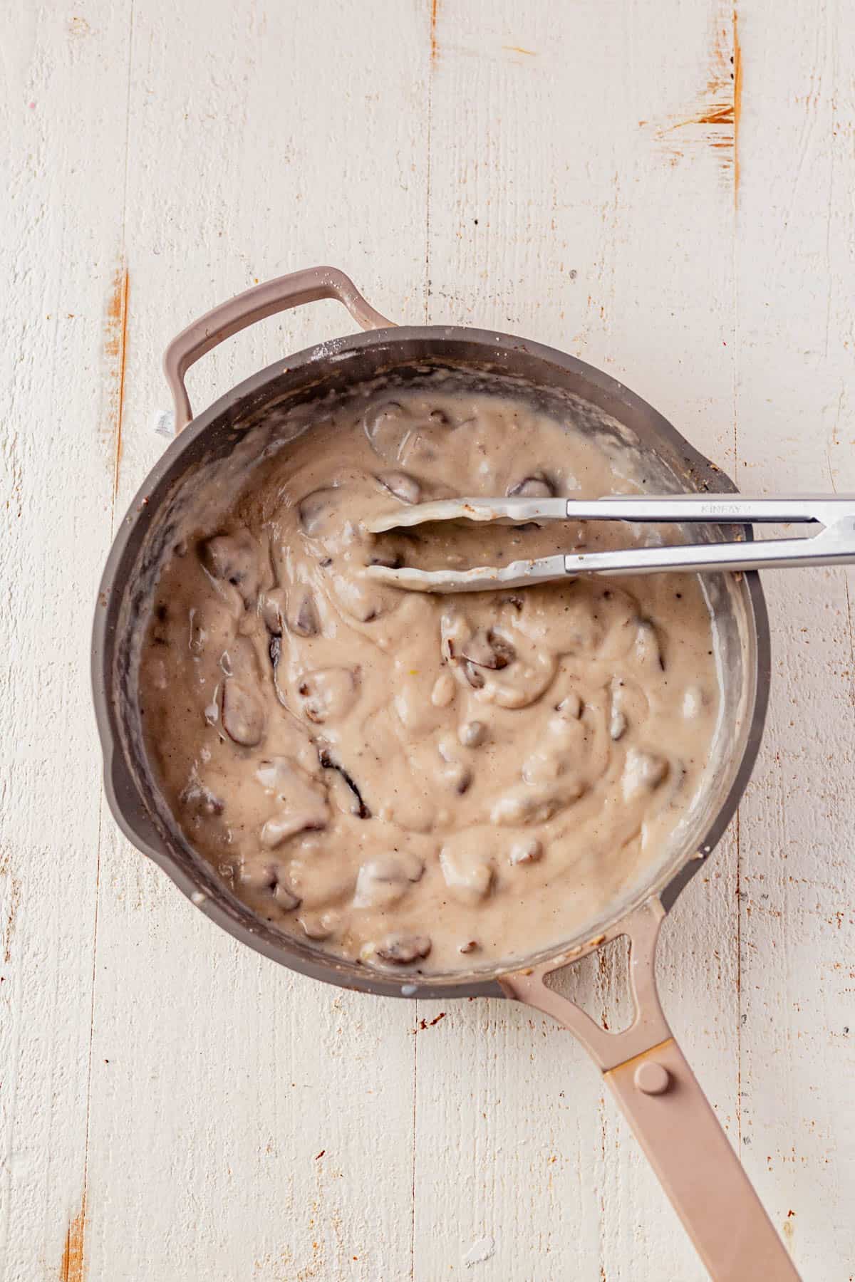 dairy free mushroom sauce in a pan with a spoon.