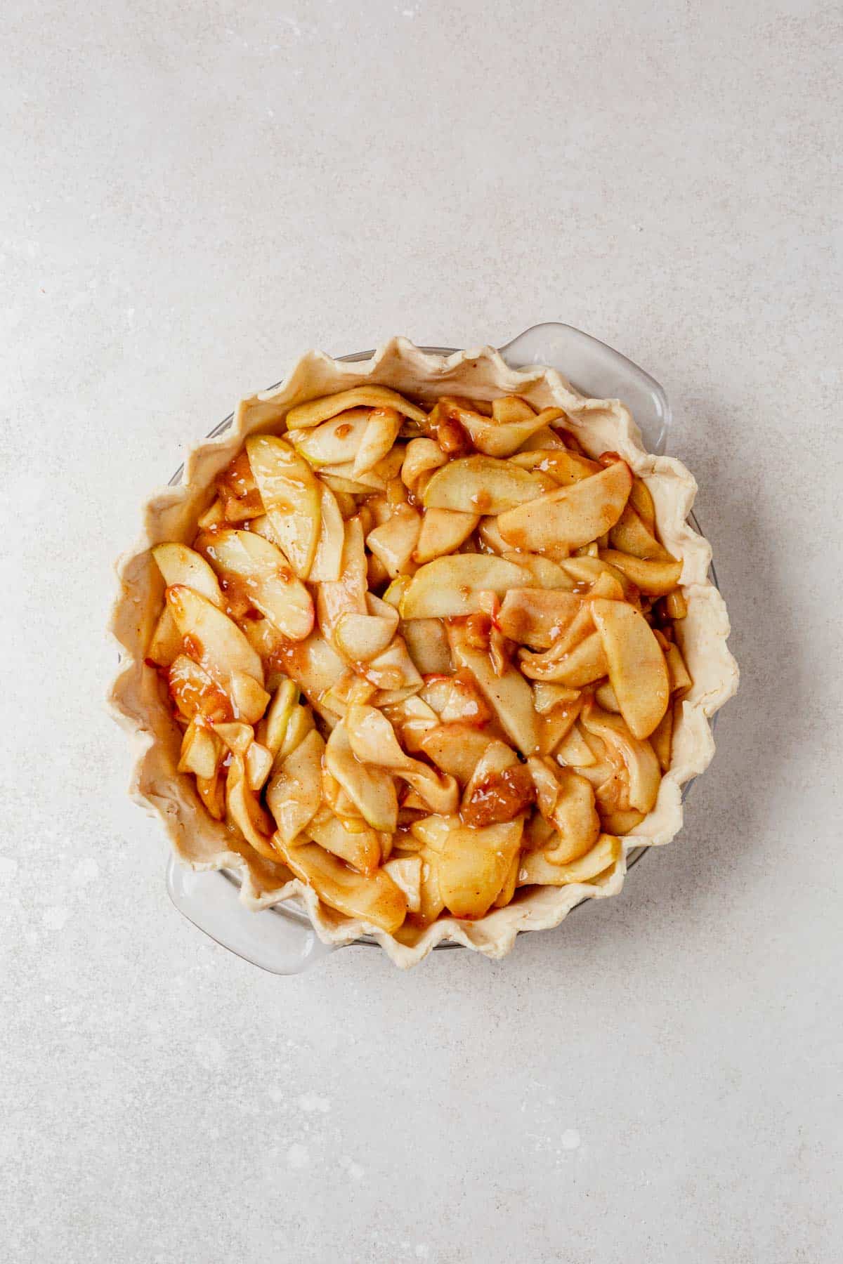 apple pie filling inside unbaked gluten free pie crust.