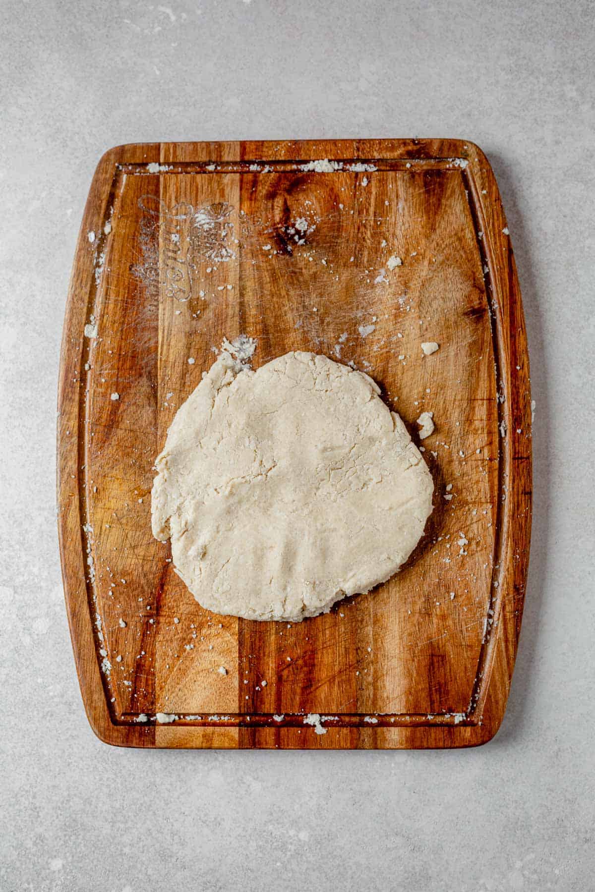 gluten free pie crust shaped into a disc on a counter top.