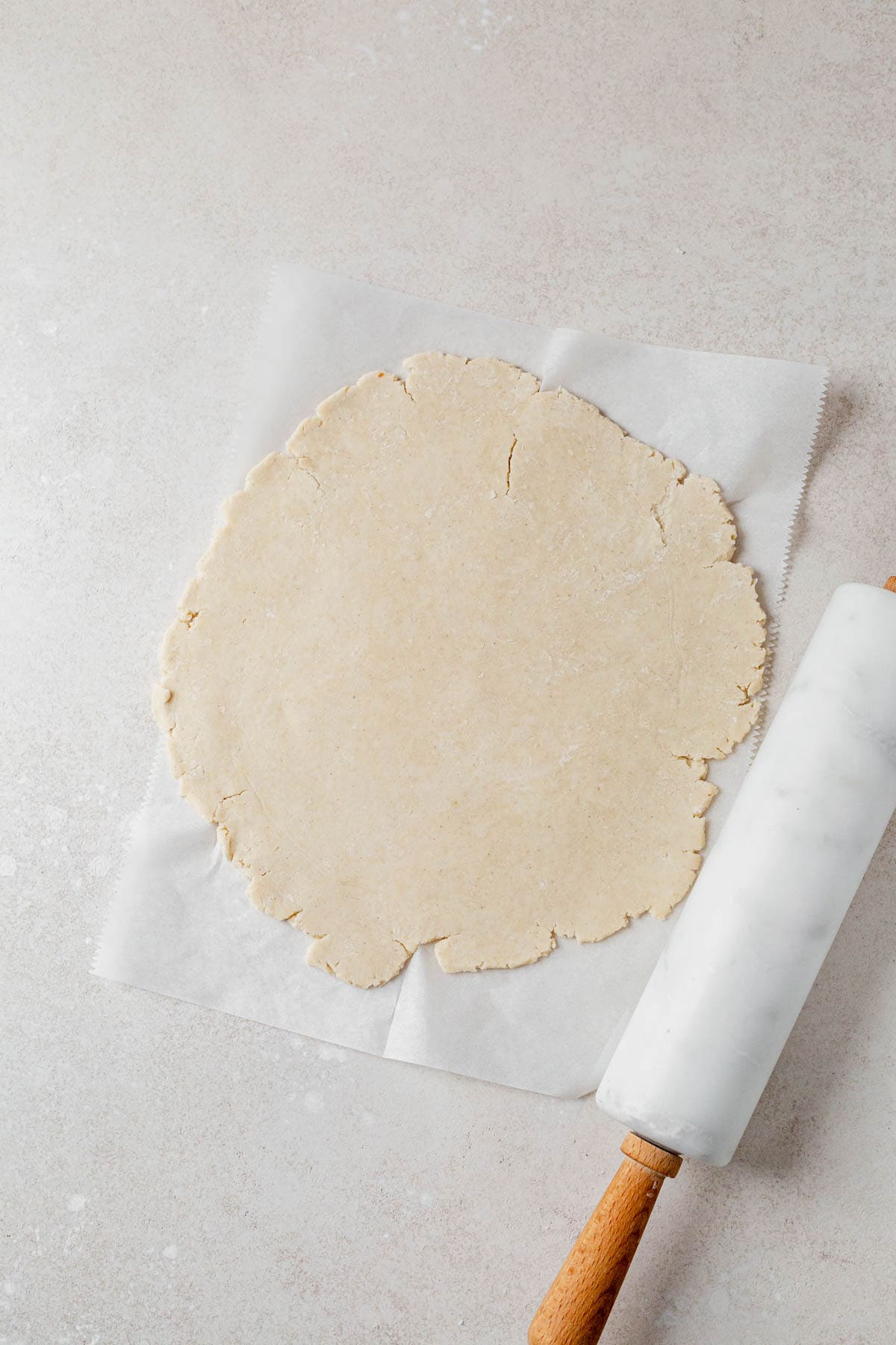 gluten free apple pie crust rolled out into a circle on a counter.