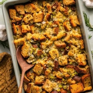 gluten free stuffing recipe in a casserole dish with a wooden serving spoon.