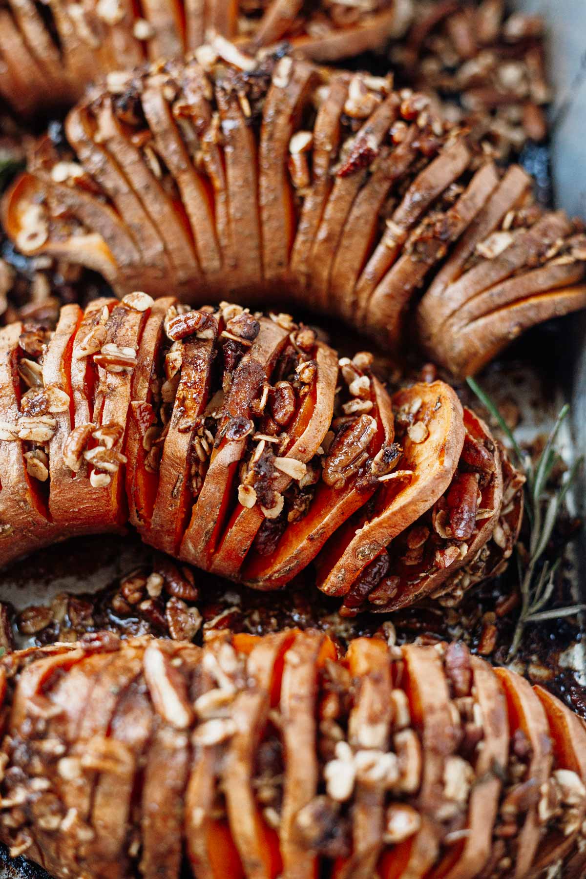 hasselback sweet potatoes thinly sliced and roasted in the oven with pecans and brown sugar