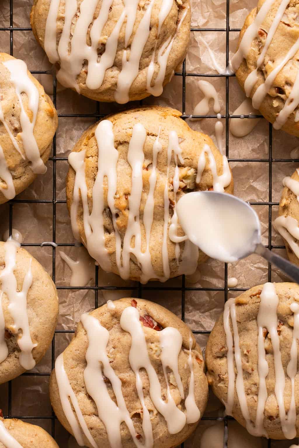 drizzling maple icing on top of fresh baked maple pecan cookies.