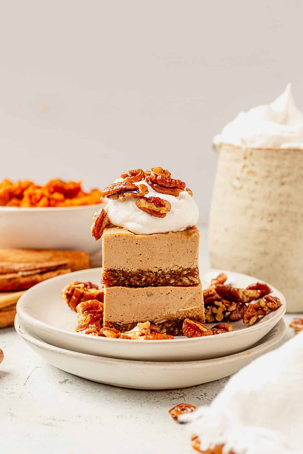 vegan pumpkin cheesecake with whipped cream and pecans
