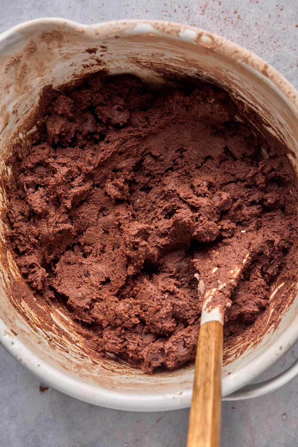 mexican hot chocolate cookie dough in a mixing bowl with a spatula.