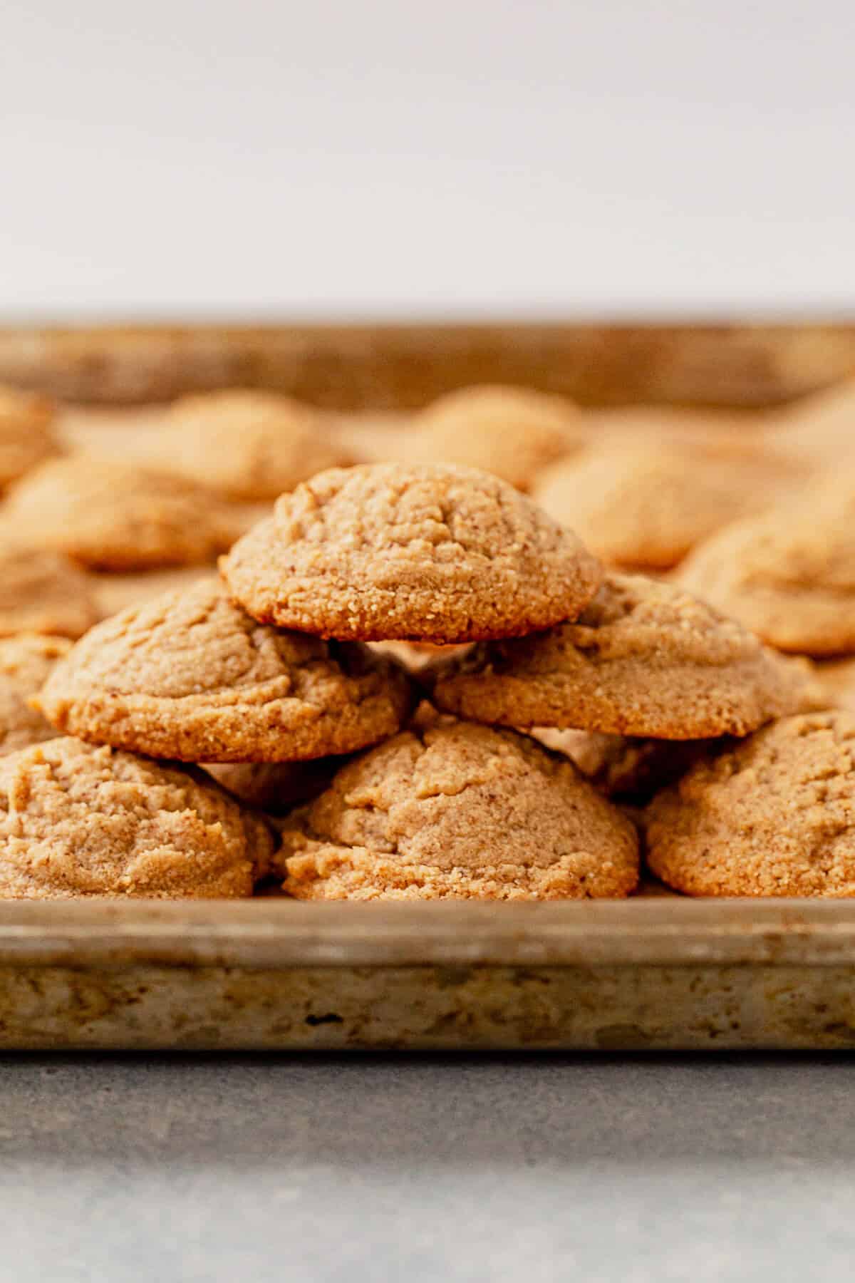 a stack of almond flour peanut butter cookies on a cookie sheet