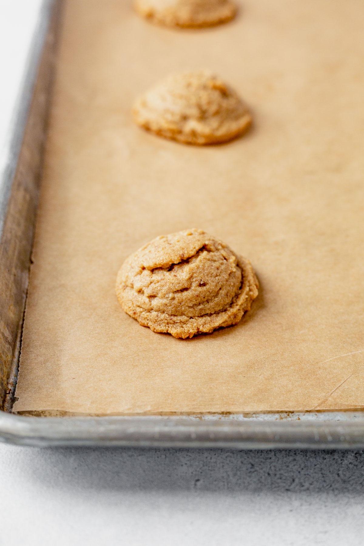 an almond flour peanut butter cookie cooling on a baking sheet