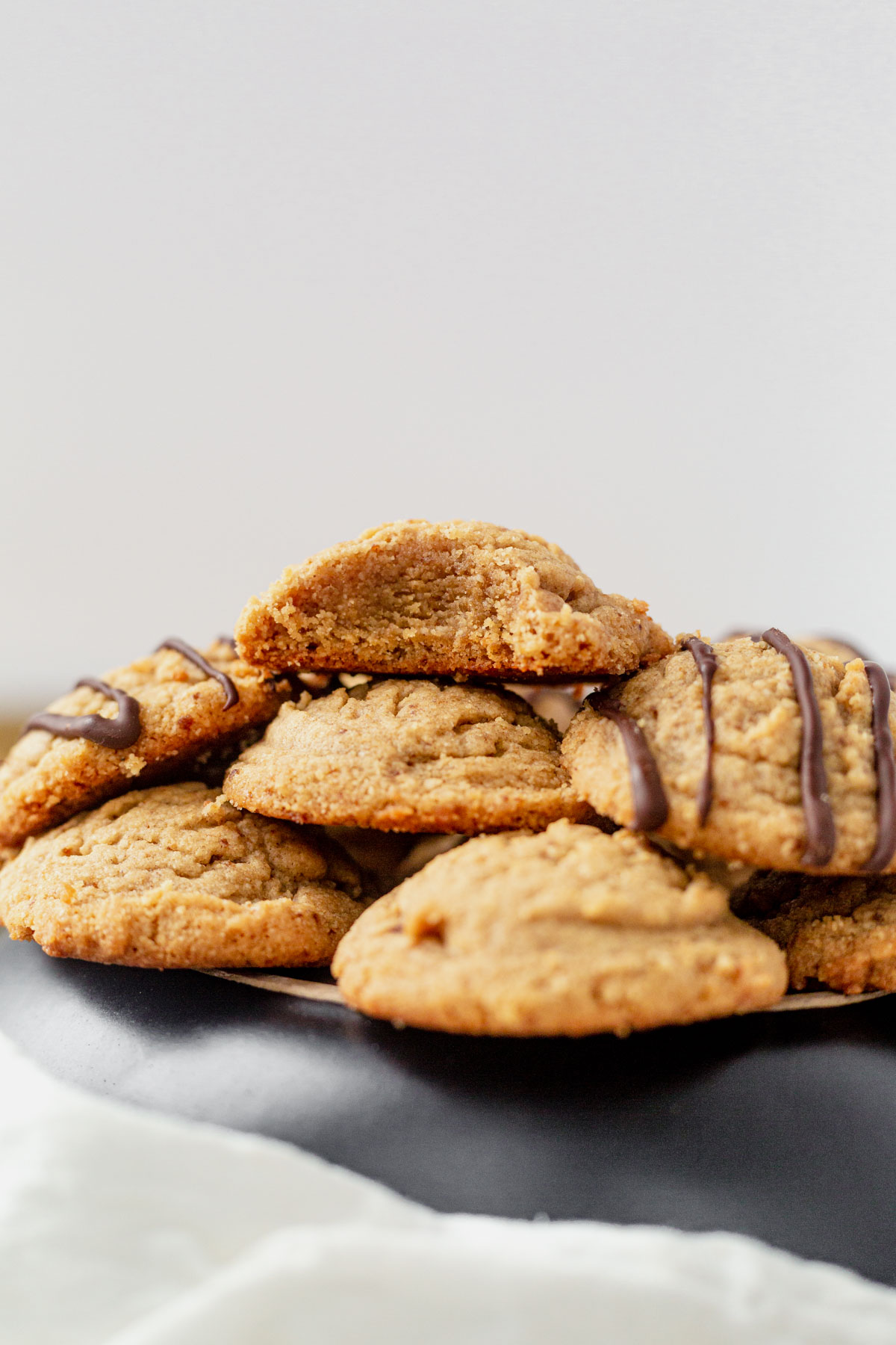 a stack of almond flour peanut butter cookies with a bite taken out of the top one