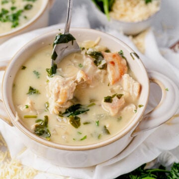 a spoon scooping a bite of chicken florentine soup