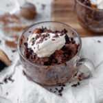 chocolate microwave bread pudding in a glass mug with whipped cream