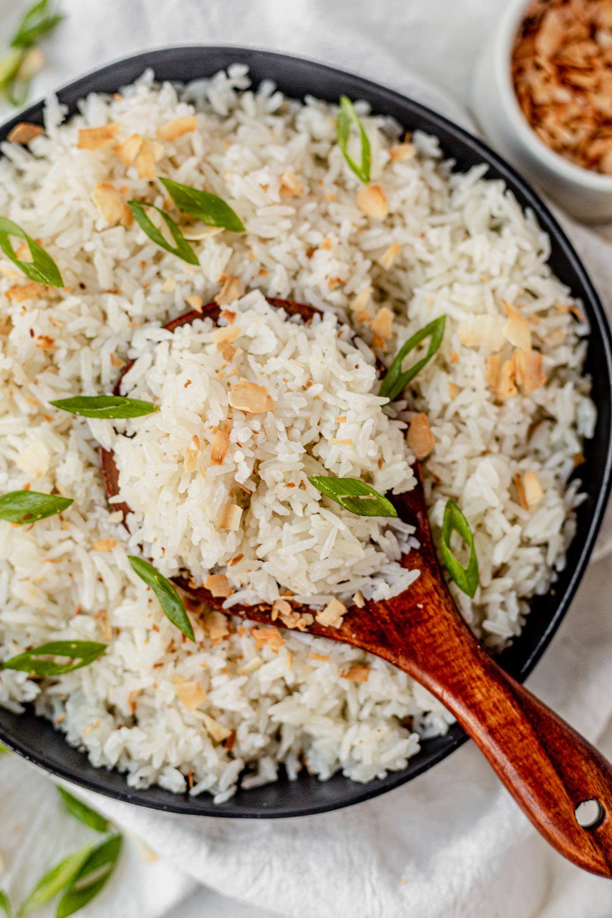 wooden rice spoon scooping instant pot coconut rice out of a bowl