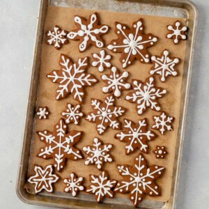 decorated snowflake cookies drying on a large baking sheet