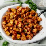 crispy air fryer breakfast potatoes in a serving dish with a spoon